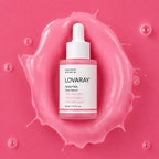 A bottle of LOVARAY PDRN Pink Face Serum centered on a glossy pink splash, with a white dropper cap and pink label accents.