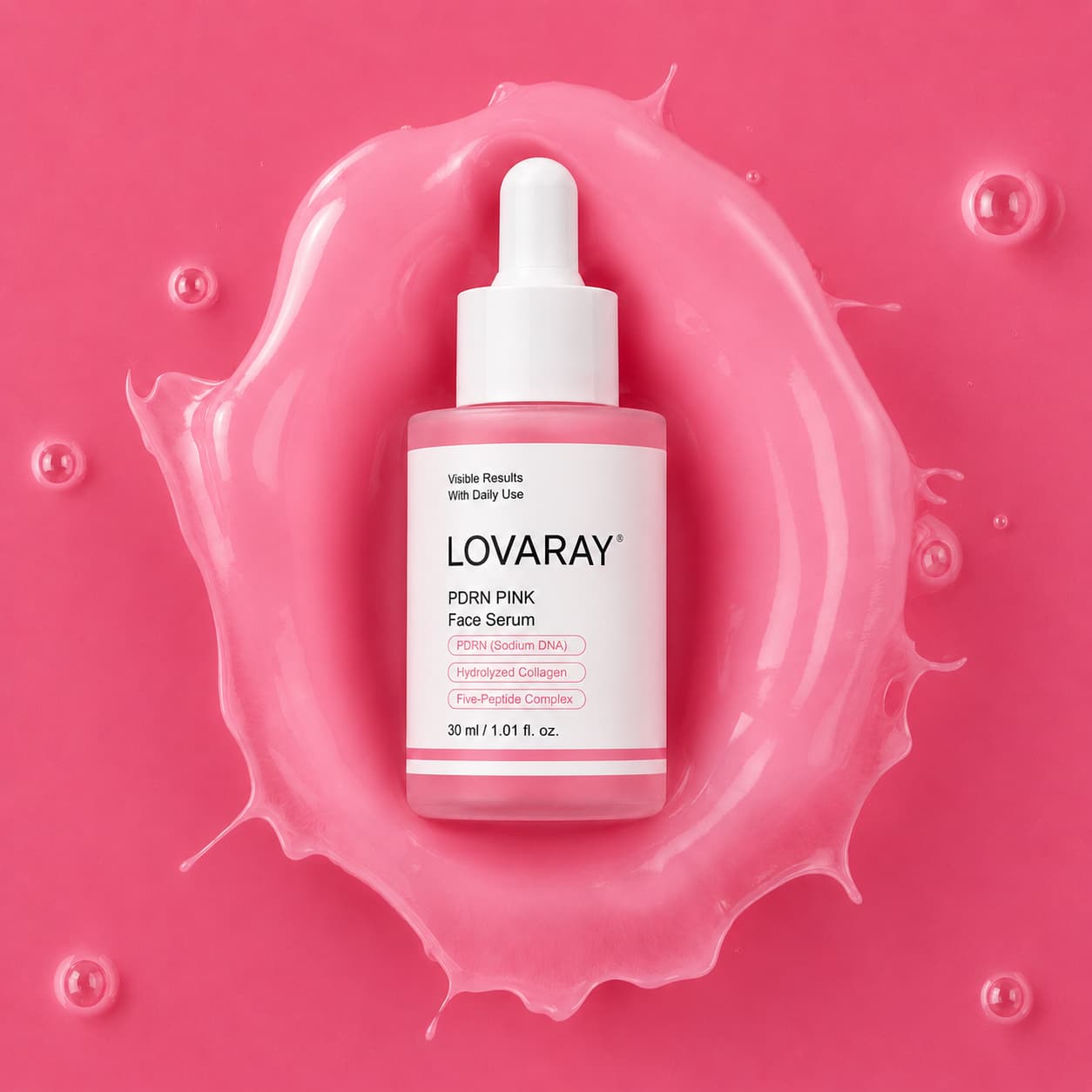 A bottle of LOVARAY PDRN Pink Face Serum centered on a glossy pink splash, with a white dropper cap and pink label accents.